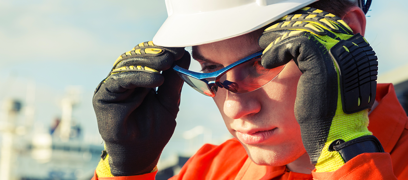 Ship worker, putting on safety glasses